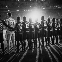 A team of eleven football players facing a football pitch, image in black and white