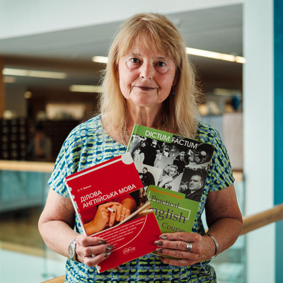 Liudmyla, 68 de ani, profesoară universitară din Odesa, ține în mâini manualul de engleză cu care și‑a învățat studenții, fotografiată în Biblioteca Națională din București