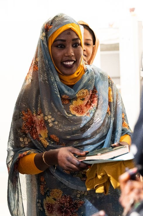 Woman smiling holding a Quran