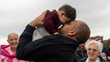 Syrian refugee holding his daughter