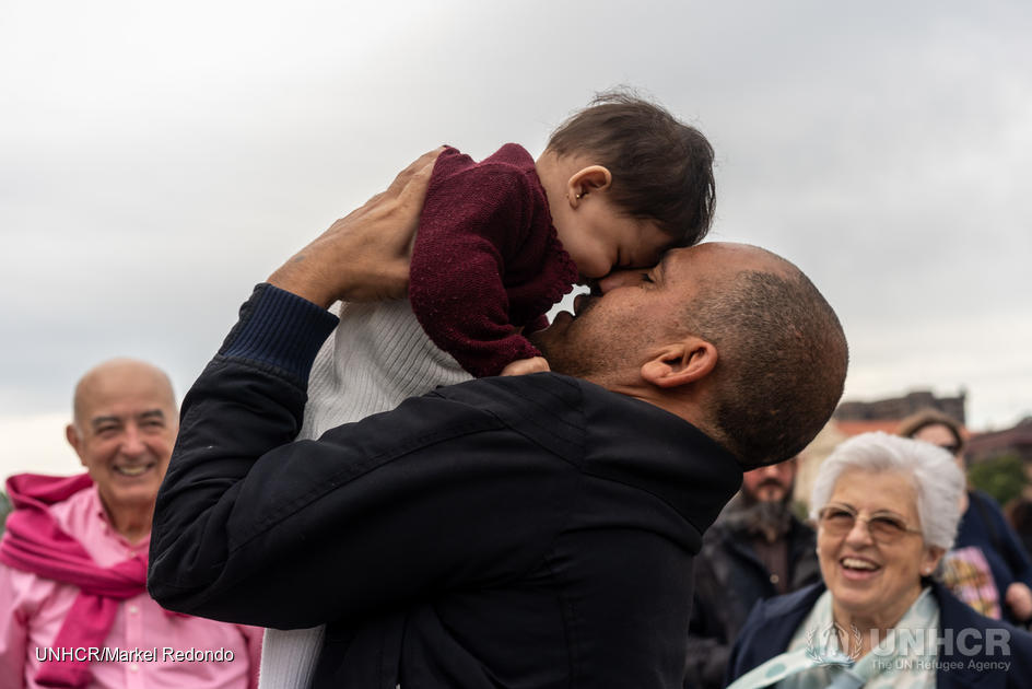 Syrian refugee holding his daughter