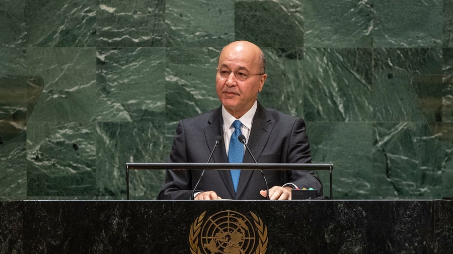 Barham Salih, wearing a suit, speaks at a podium bearing the United Nations emblem