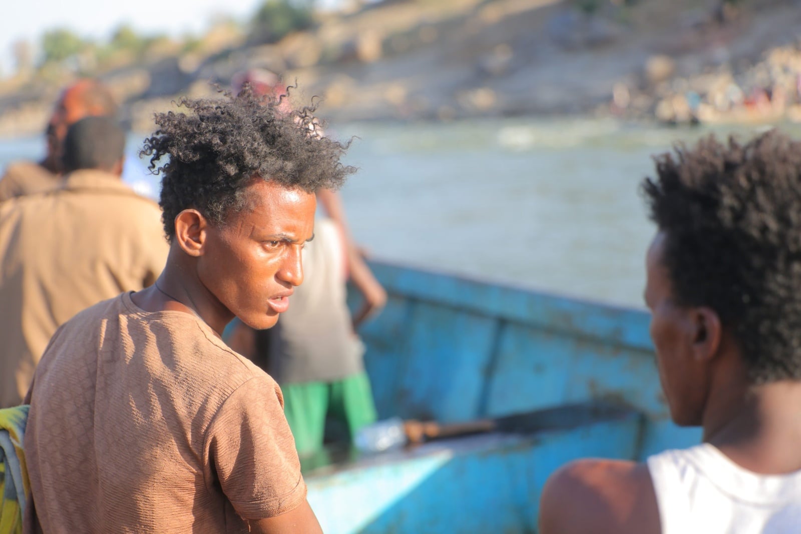Ethiopische vluchtelingen, op de vlucht voor conflict in de Tigrayregio van het land, halen overlevingsmateriaal van een boot op de Tekezerivier nadat ze de grens zijn overgestoken naar Hamdayet, Soedan. © UNHCR/Hazim Elhag
