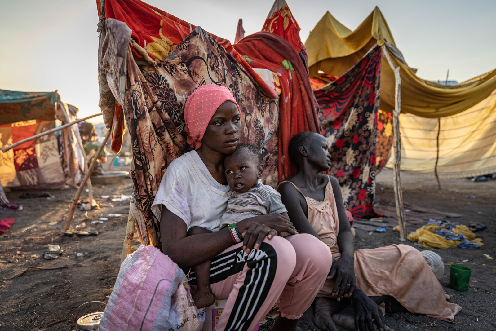 Nyauke Chianjiak, une réfugiée sud-soudanaise de retour au pays, avec sa sœur d'un an, Kuoli, et sa mère Naya, dans un centre de transit près de Renk, au Soudan du Sud. © HCR/ Andrew McConnell