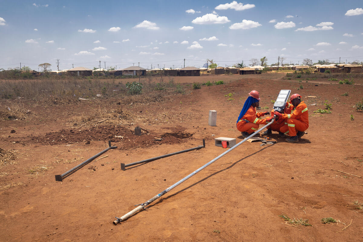 Displaced people install a new street light at Corrane IDP site in Nampula Province, Mozambique.