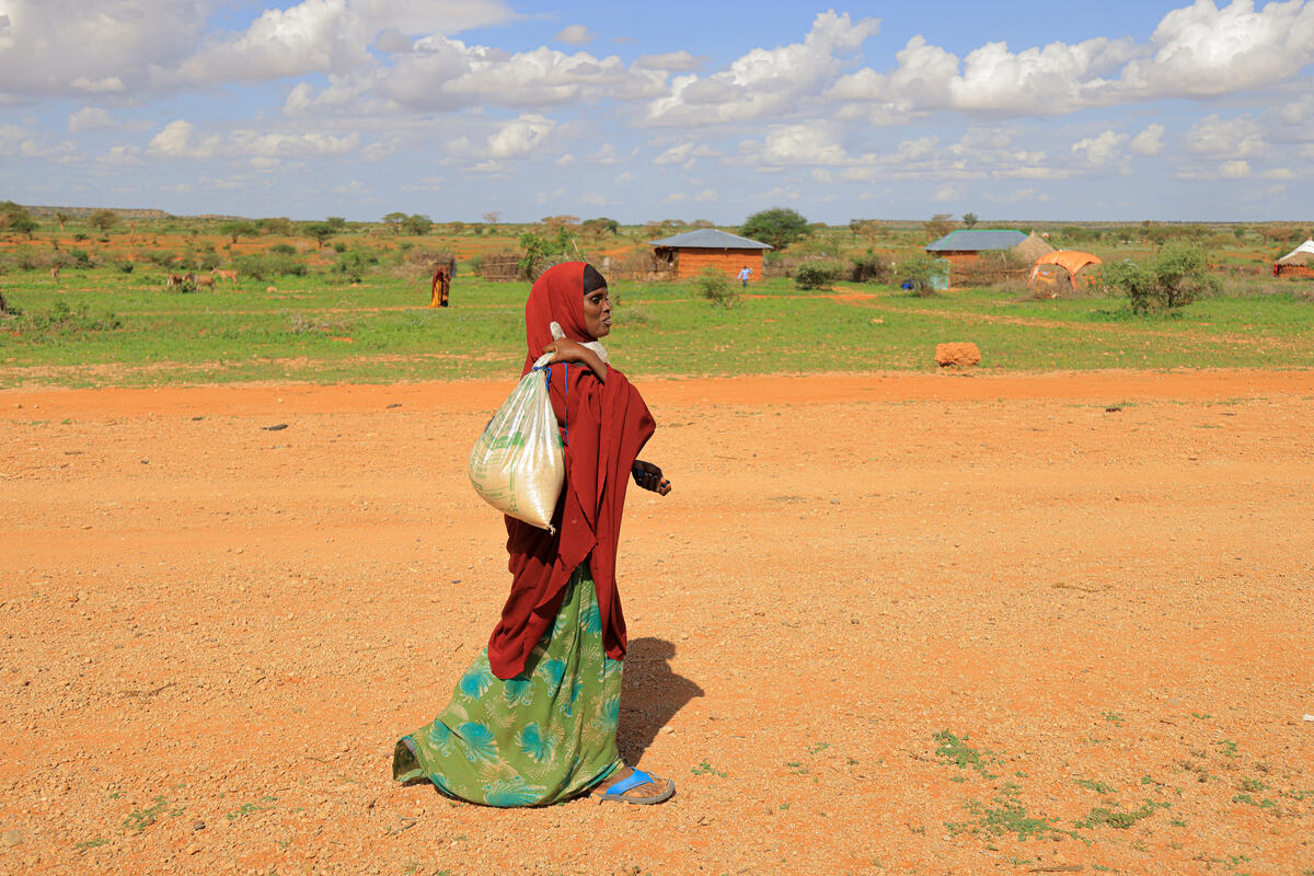 Ethiopia. Ilama Ahmed, 31, an Internally Displaced Person walks home with groceries she purchased from a shop owner, Ahmed Salah Ahmed in Darso camp for the Internally Displaced Person