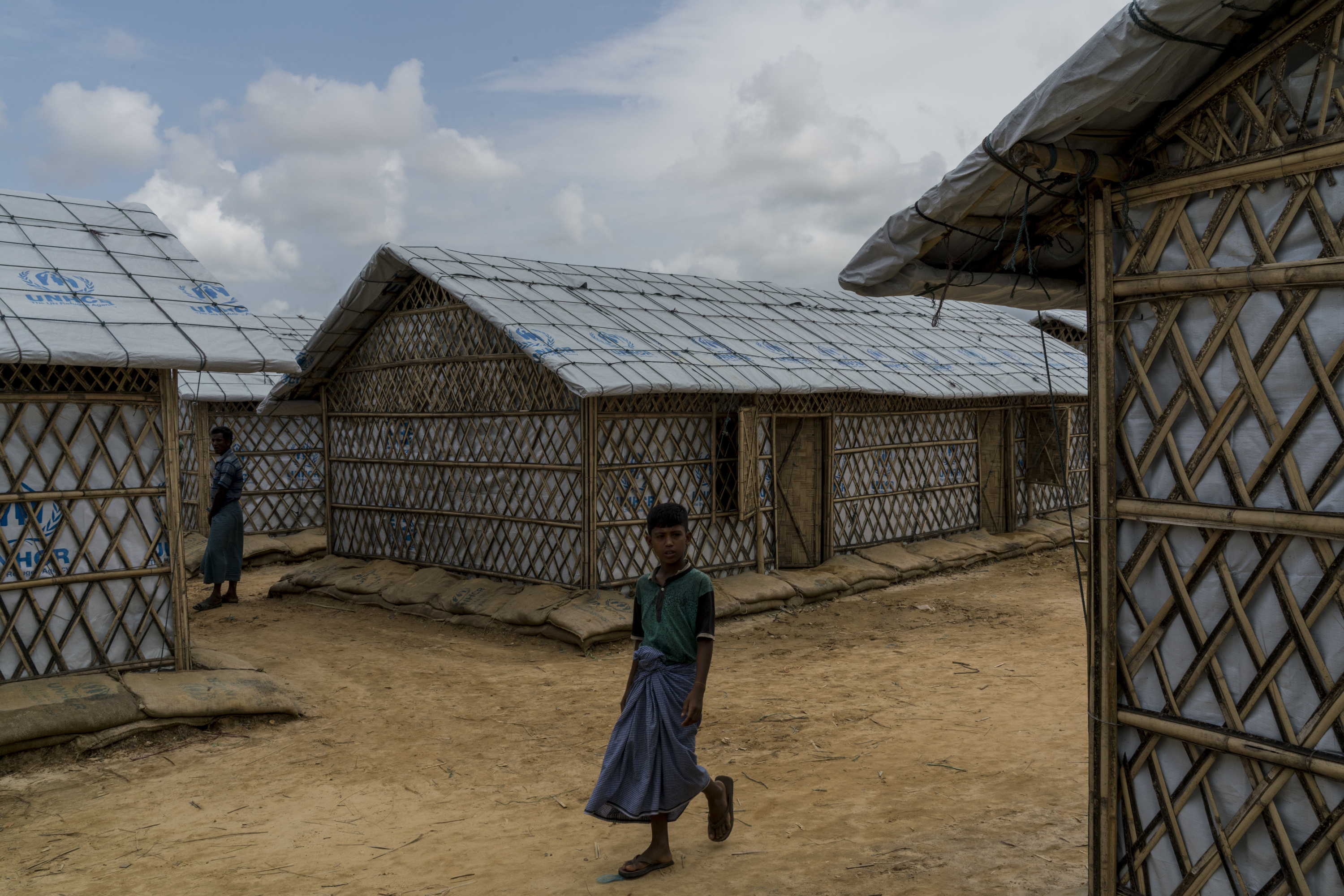 Rohingya refugees, who were living in tents at risk of landslides in Kutupalong Camp 5, walk around the new Camp 4 Extension after being relocated, in Kutupalong refugee camp in Bangladesh on June 30th, 2018.