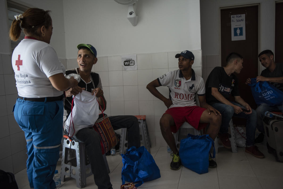 Colombia. Red Cross volunteer talks with migrants