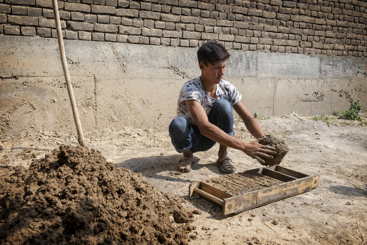 Kyrgyzstan. Nazir Khatamov, 21, making bricks for construction houses