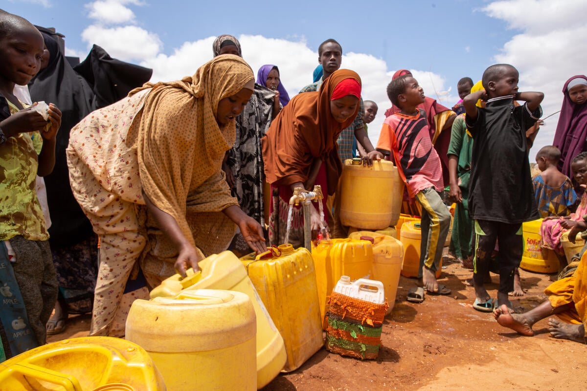 Personas refugiadas recién llegadas de Somalia esperan turno para recoger agua de un depósito en el campamento de Dagahaley, en Dadaab, Kenia.
