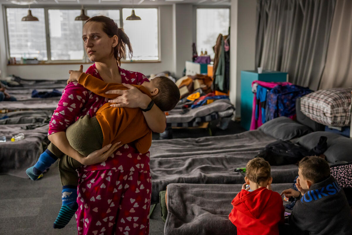 Kateryna sostiene a Arsen, su hijo de dos años, en el albergue en el que ella y su familia viven junto a otras 400 personas refugiadas de Ucrania. Si bien su esposo consiguió un empleo, no han encontrado un apartamento propio.