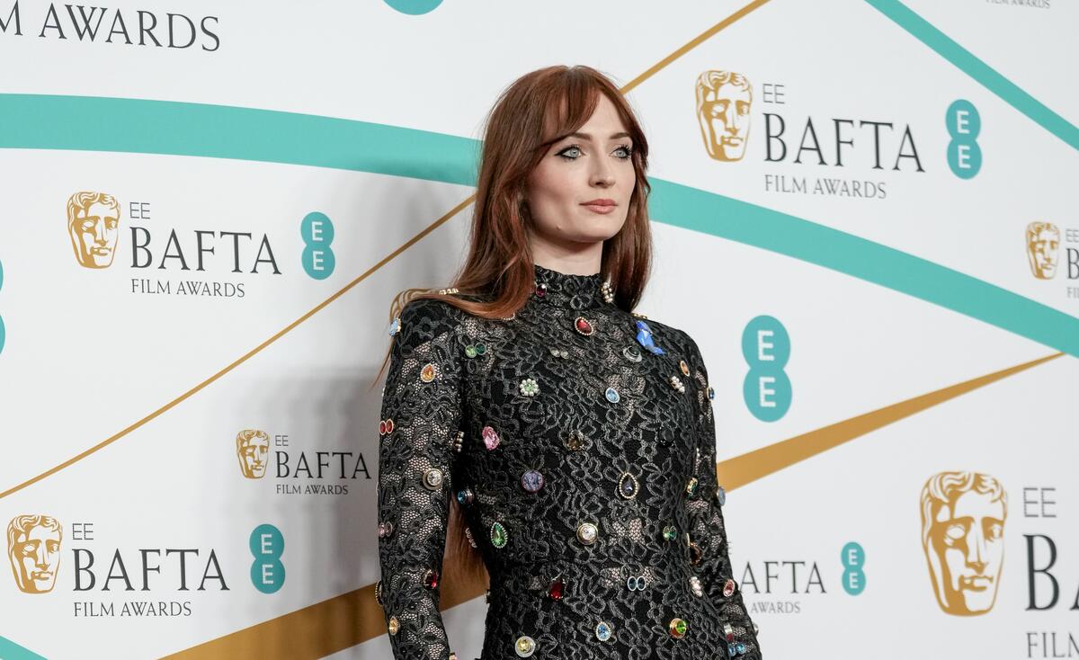 United Kingdom. Actor Sophie Turner wears a blue ribbon in solidarity with refugees at the EE BAFTA Film Awards 2023