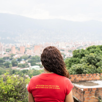 A woman pictured from behind, looking out across downtown Medellín, Colombia