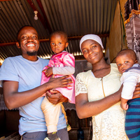 A smiling mother and father hold their two children.
