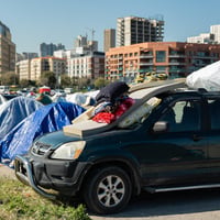 Tents and cars line Beirut's waterfront, sheltering displaced families.