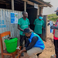 UNHCR staff inspect a chlorinated handwashing station