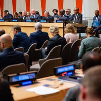 Delegates and officials attend a meeting at UN Headquarters, with speakers seated on a panel before an audience.