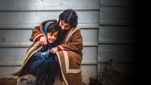 Una niña y un niño se cubren con una manta