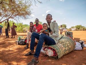 الأخوان نور موسى نور (يمين) وعبدي شكر (يسار) ينتظران مع أطفالهما بالقرب من الحدود ليتم نقلهم إلى مخيم ميركان في المنطقة الصومالية في إثيوبيا.