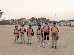 Six boys in baseball uniforms attend a traning session