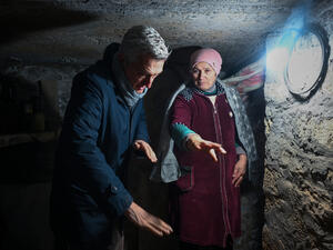 UNHCR's Filippo Grandi stands in a bunker with a woman from Ukraine.