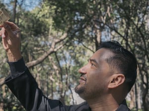 Un homme regarde une carte d'identité qu'il brandit.