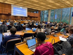 Attendees in a conference room. The large screen displays "Opening remarks: H.E. Mr Gustavo Gallón"