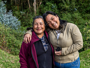 An Ecuadorian woman, 67, and a Venezuelan woman, 39 embrace and celebrate their friendship on the banks of a river.