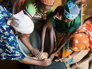 Des femmes nigérianes et des habitantes de la région travaillent ensemble pour produire de l'huile d'arachide dans un « village d'opportunité » soutenu par le HCR au centre-sud du Niger. 