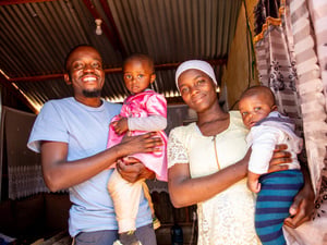 A smiling mother and father hold their two children.