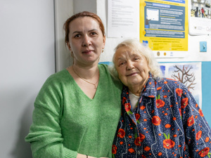 Une jeune femme et une femme plus âgée se tiennent ensemble, les bras enlacés.