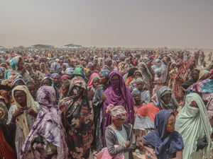 A huge crowd of refugees wait for food.