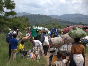 Congolese families walking with their belongings on their heads and backs