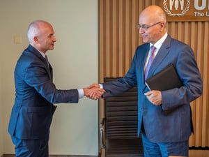 Barham Salih and Óscar García Maceiras shake hands, smiling