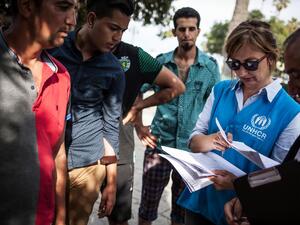 UNHCR staffer helps refugees and migrants to register at the local police station on Kos Island in Greece.