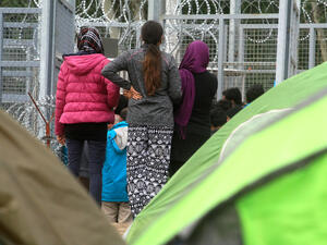 Hungary. Afghan refugee girls patiently waiting as someone is granted access to the tranzit zone in Röszke