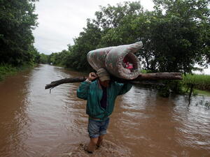 Honduras. Man carries his belongings through a flooded road after the passing of Storm Iota, in Marcovia