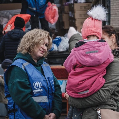 Anzhela (24) holds her little niece Liliya (4) as they wait to receive warm clothes and blankets.