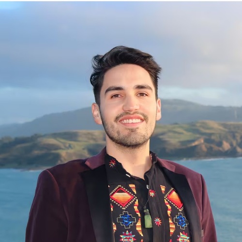 Daniel Gamboa smiles with the ocean and a coastline behind him