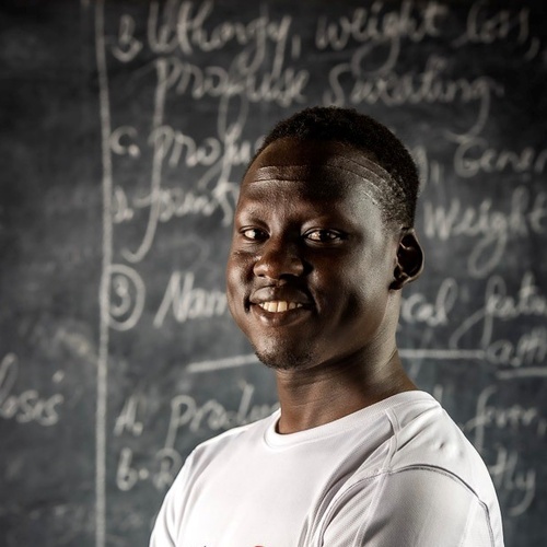 Lam Joar poses in front of a blackboard