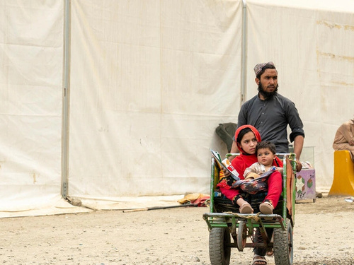 Hadigul porte ses jeunes sœurs, Sabria et Freshta, alors qu’ils voyagent ensemble après leur récent retour en Afghanistan. Malgré les épreuves qu’ils ont traversées, cette famille très unie fait preuve de résilience et de force pour aller de l’avant.
