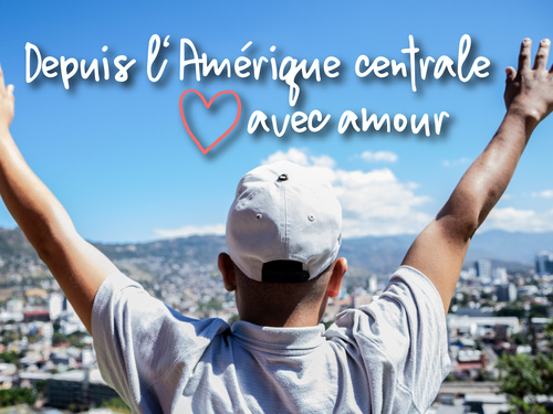 Une personne se tient debout, les bras en l'air, et regarde une ville.