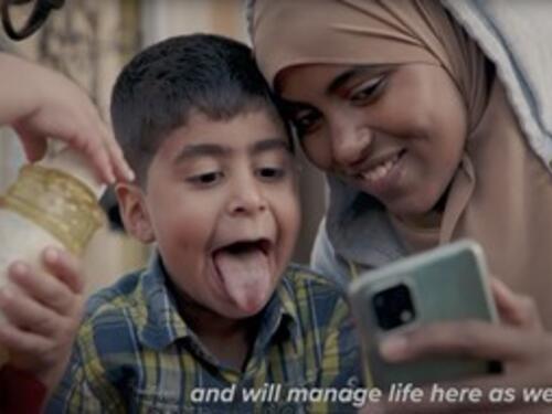 A playful mother and child look at a mobile phone
