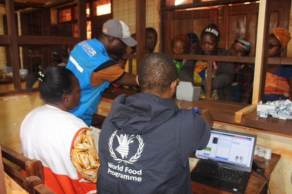 A man demonstrating a registration device to capture fingerprints