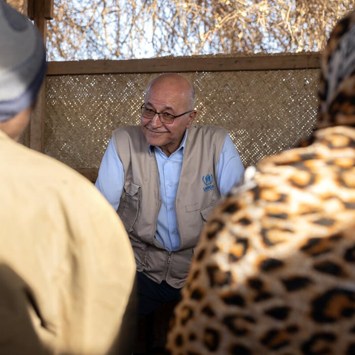 Barham Salih pictured speaking with two people whose backs are to the camera.