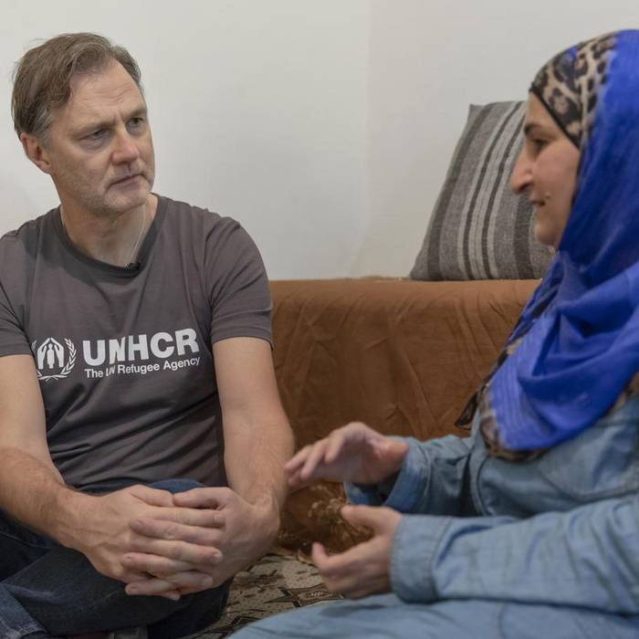 David Morrissey listens to Faiza, a refugee woman.