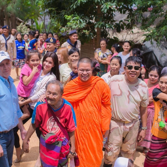 Venerable Phra Medhivajirodom surrounded by a huge group of people.