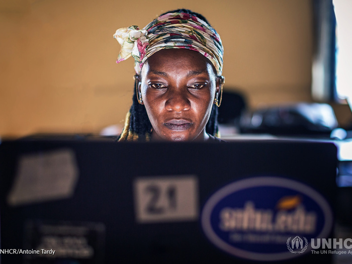 A woman looks at the screen of her laptop