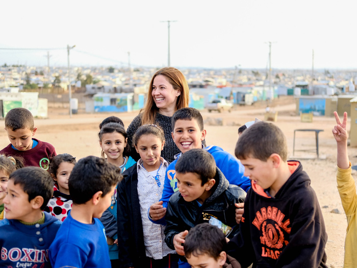 Raya Abirached smiles, surrounded by a group of children