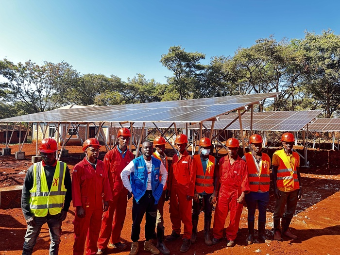 men standing around a solar-powered health centers in Tanzania